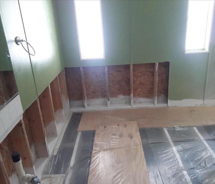 room gutted of drywall and flooring
