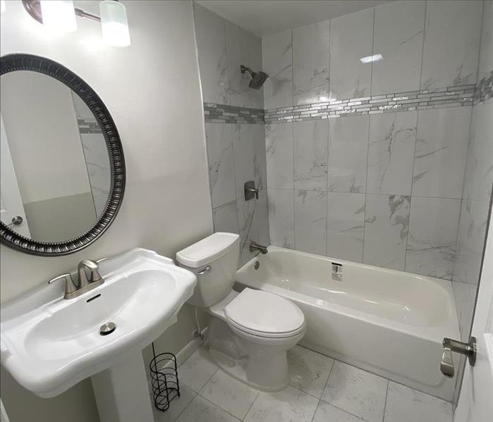 White bathroom with toilet, sink and bathtub