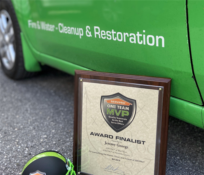 award sitting in front of a green truck on the road